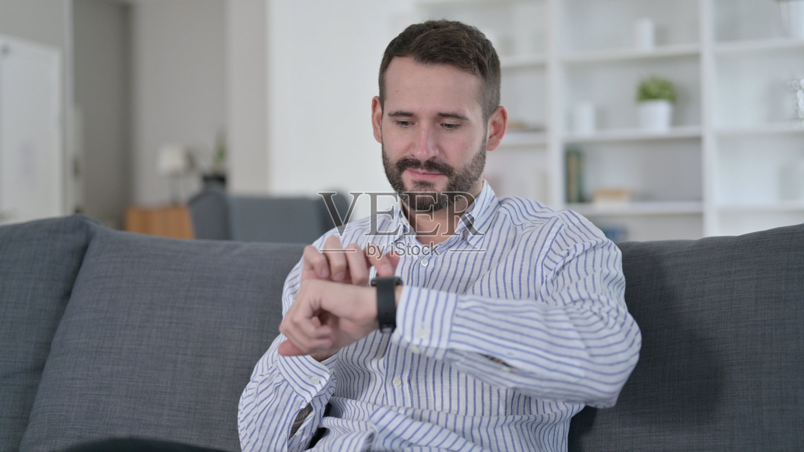 有魅力的年轻人在家使用智能手表照片摄影图片