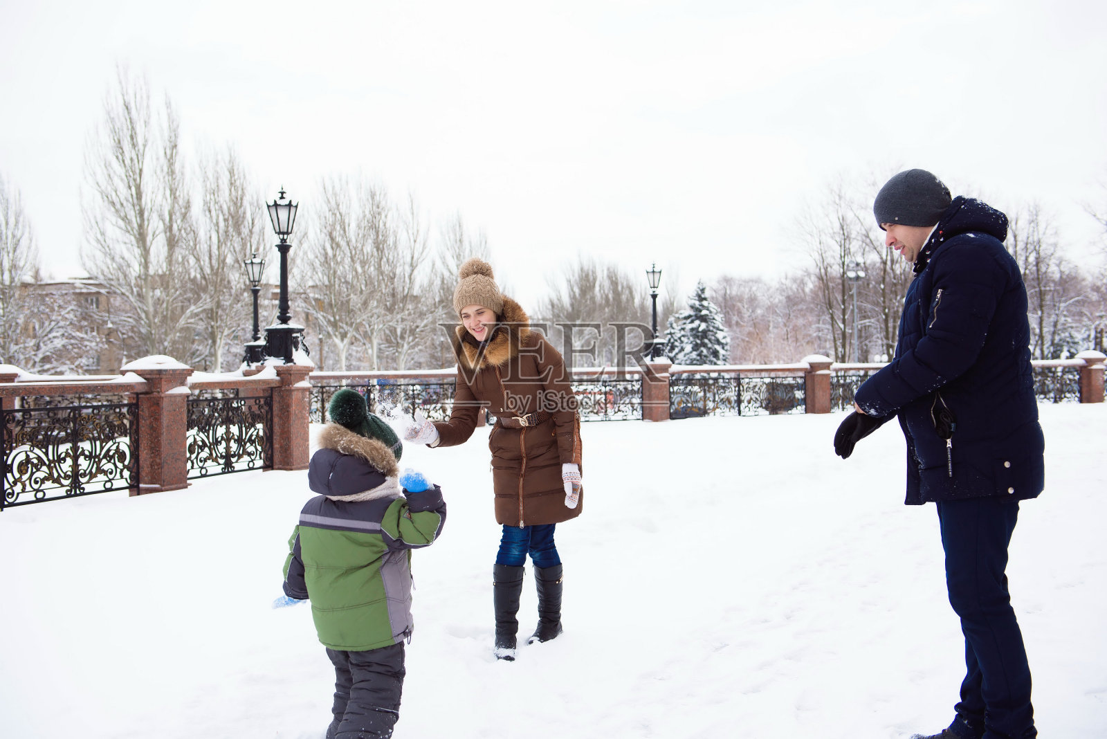 家庭母亲和女儿玩得很开心，在冬天的户外散步照片摄影图片