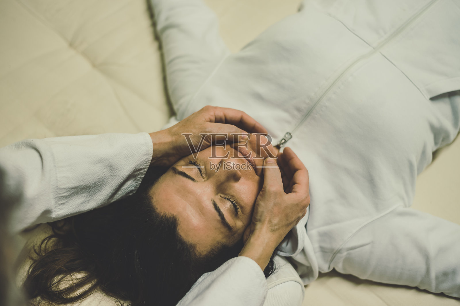 治疗师在给一个女人做指压按摩。整体疗法，用拇指、手指和手掌进行手法治疗。健康，健康，放松，幸福和替代医学概念。照片摄影图片