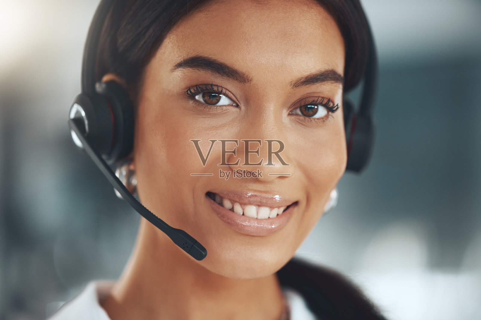 一个年轻的呼叫中心工作人员独自坐在办公室里照片摄影图片