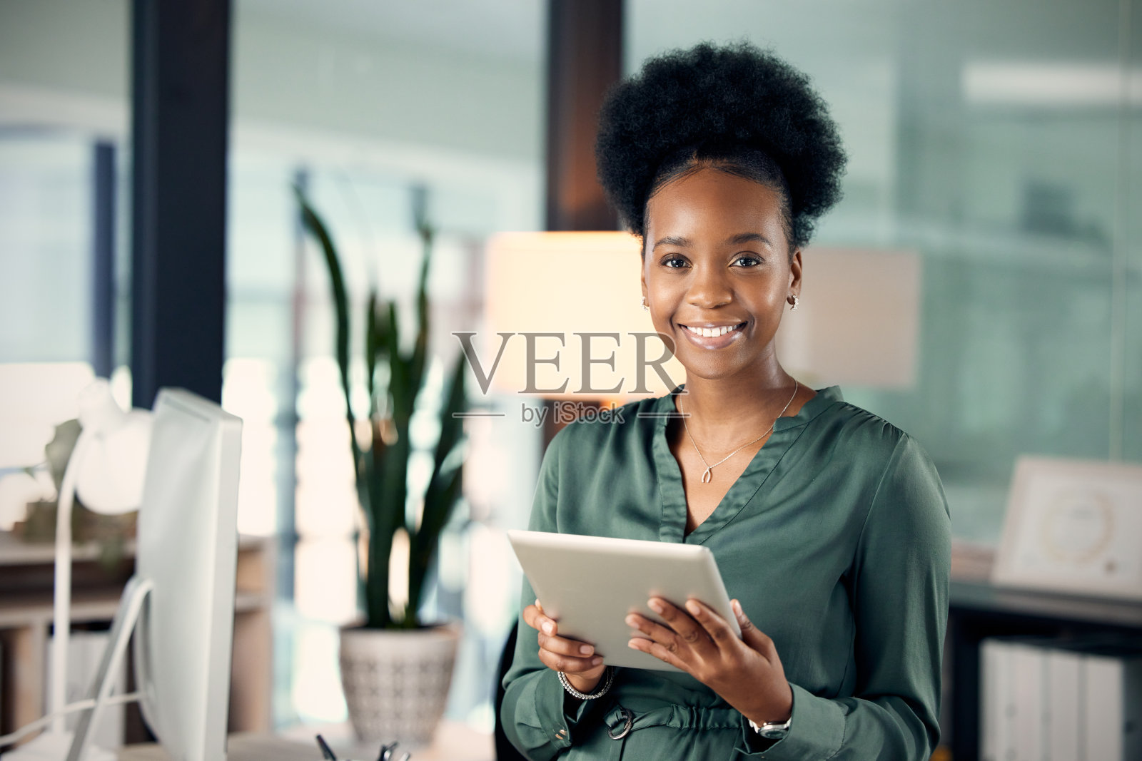 一名年轻的女商人在办公室里使用平板电脑照片摄影图片
