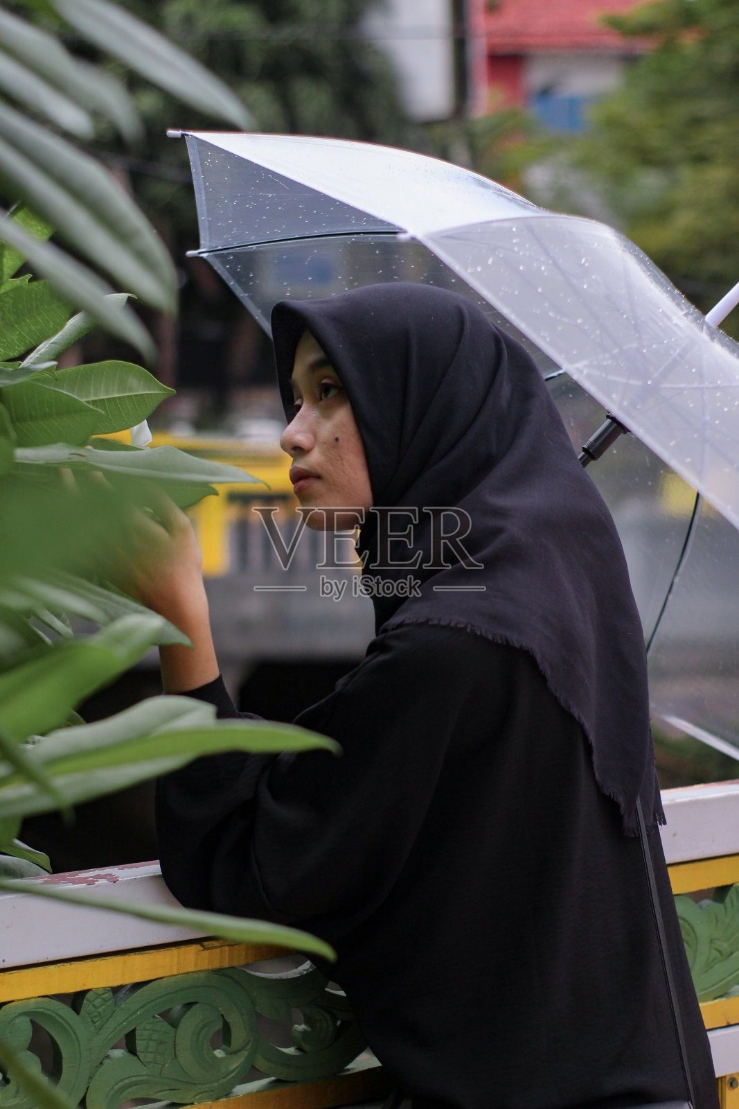亚洲妇女打着伞站在城市公园里照片摄影图片