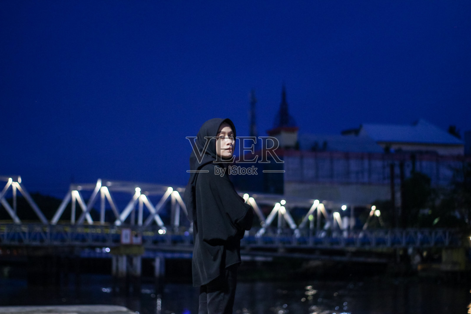 年轻的亚洲希贾布站在晚上享受照片摄影图片