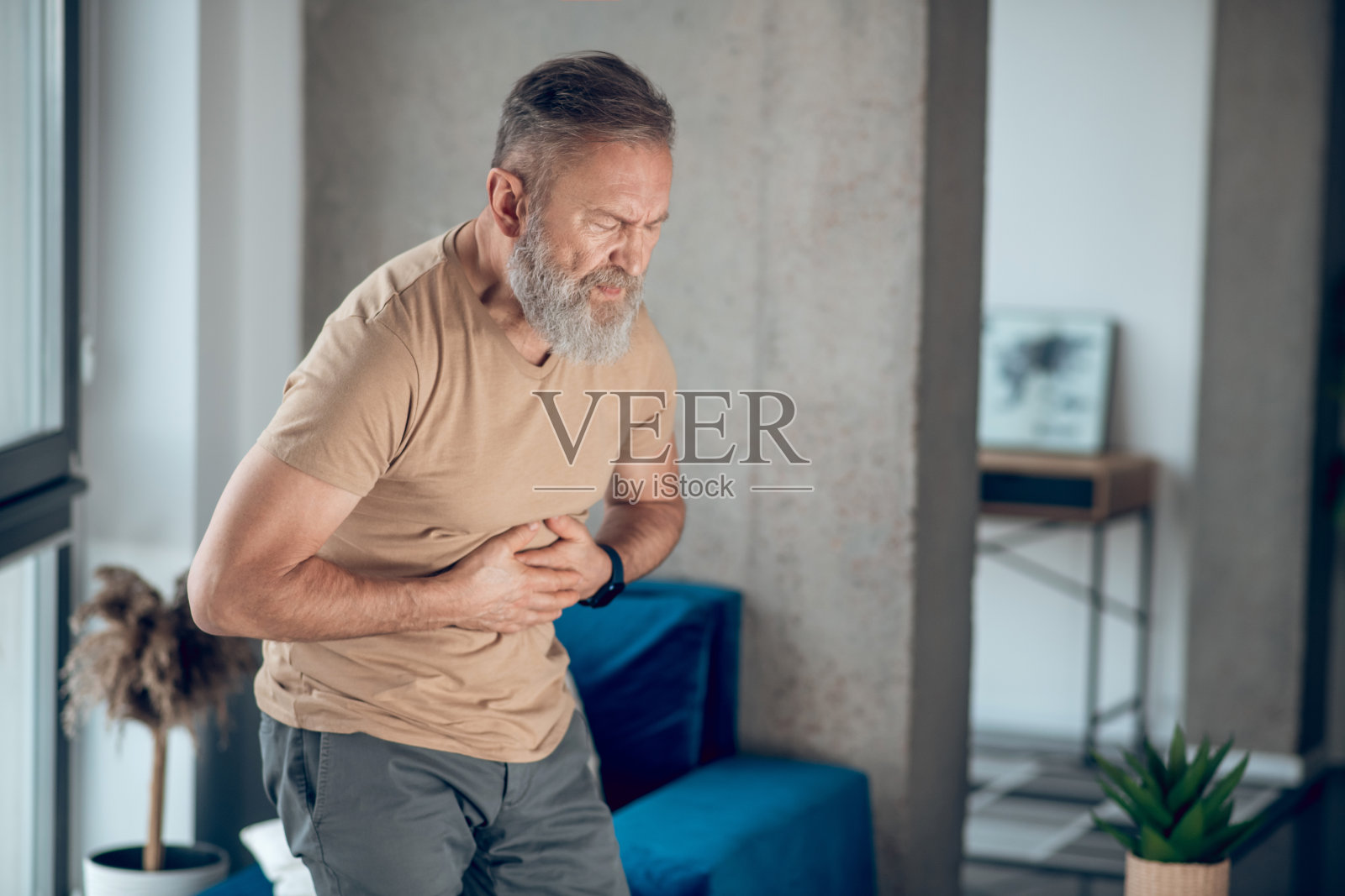一个患有胃痛的成熟男人照片摄影图片