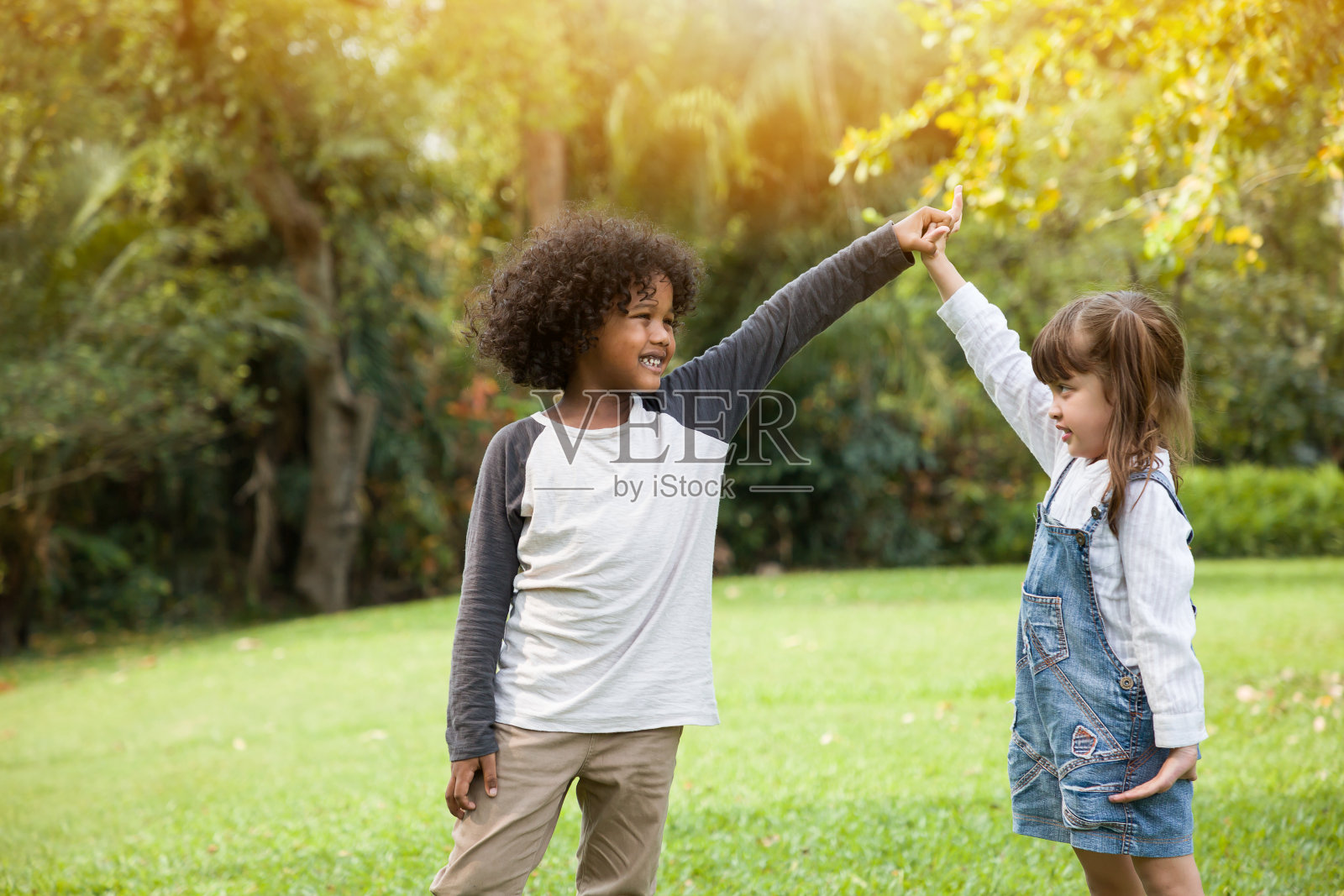 孩子们在夏天的花园里手牵着手玩照片摄影图片