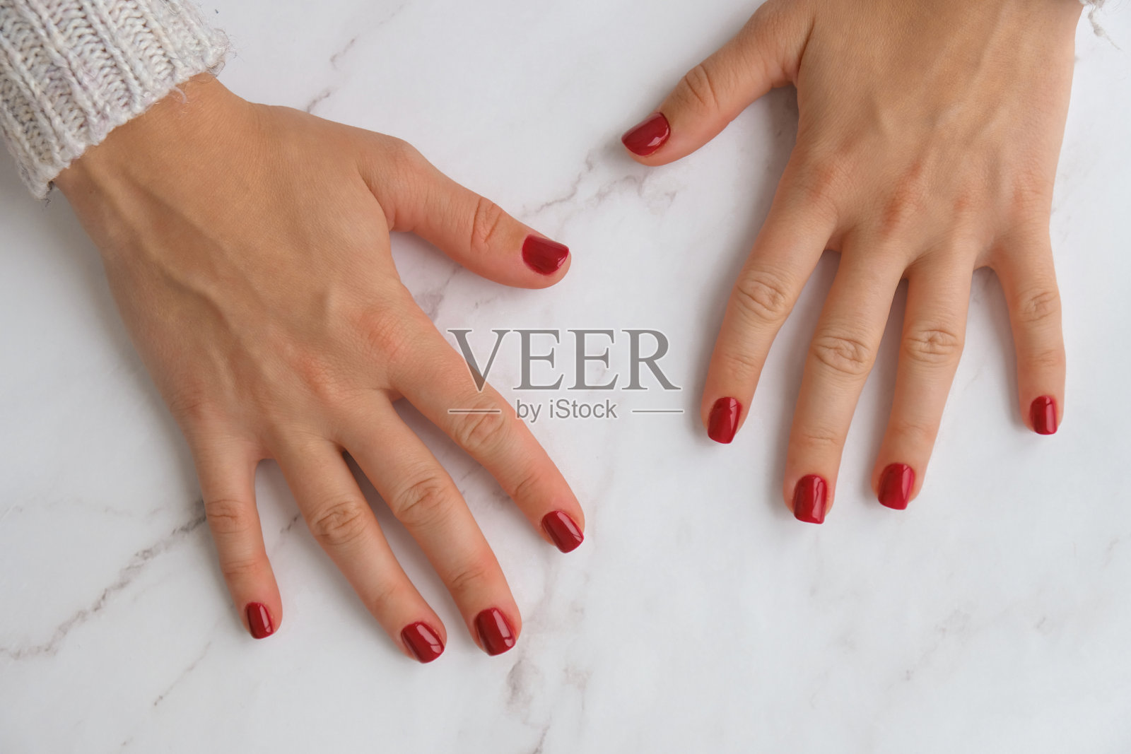 时尚的红色女性指甲。现代的漂亮的指甲。秋冬美甲设计理念美容治疗。凝胶的指甲。皮肤护理照片摄影图片