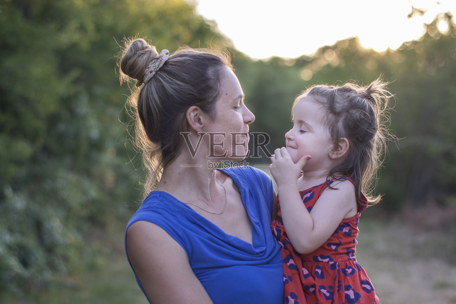 母亲在大自然中抱着她的小女儿照片摄影图片