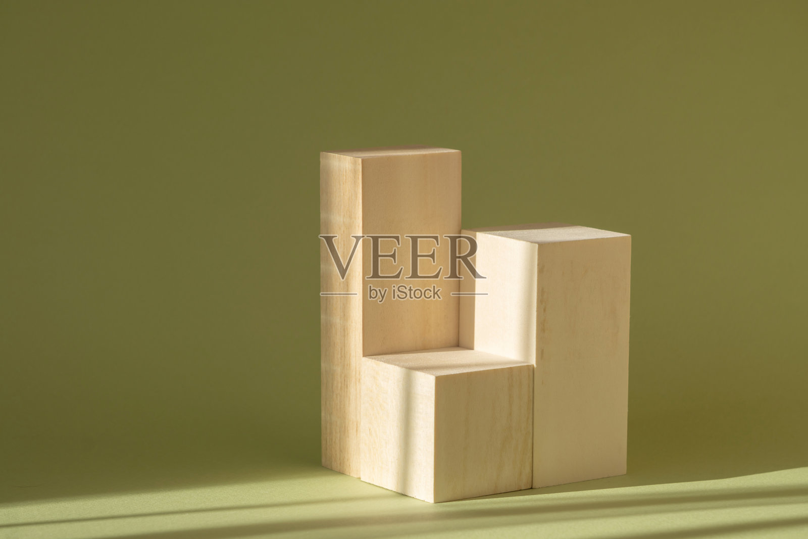 在阳光的光线下，在绿色的背景上模拟木制方架。几何三维讲台展示化妆品，展示商品照片摄影图片