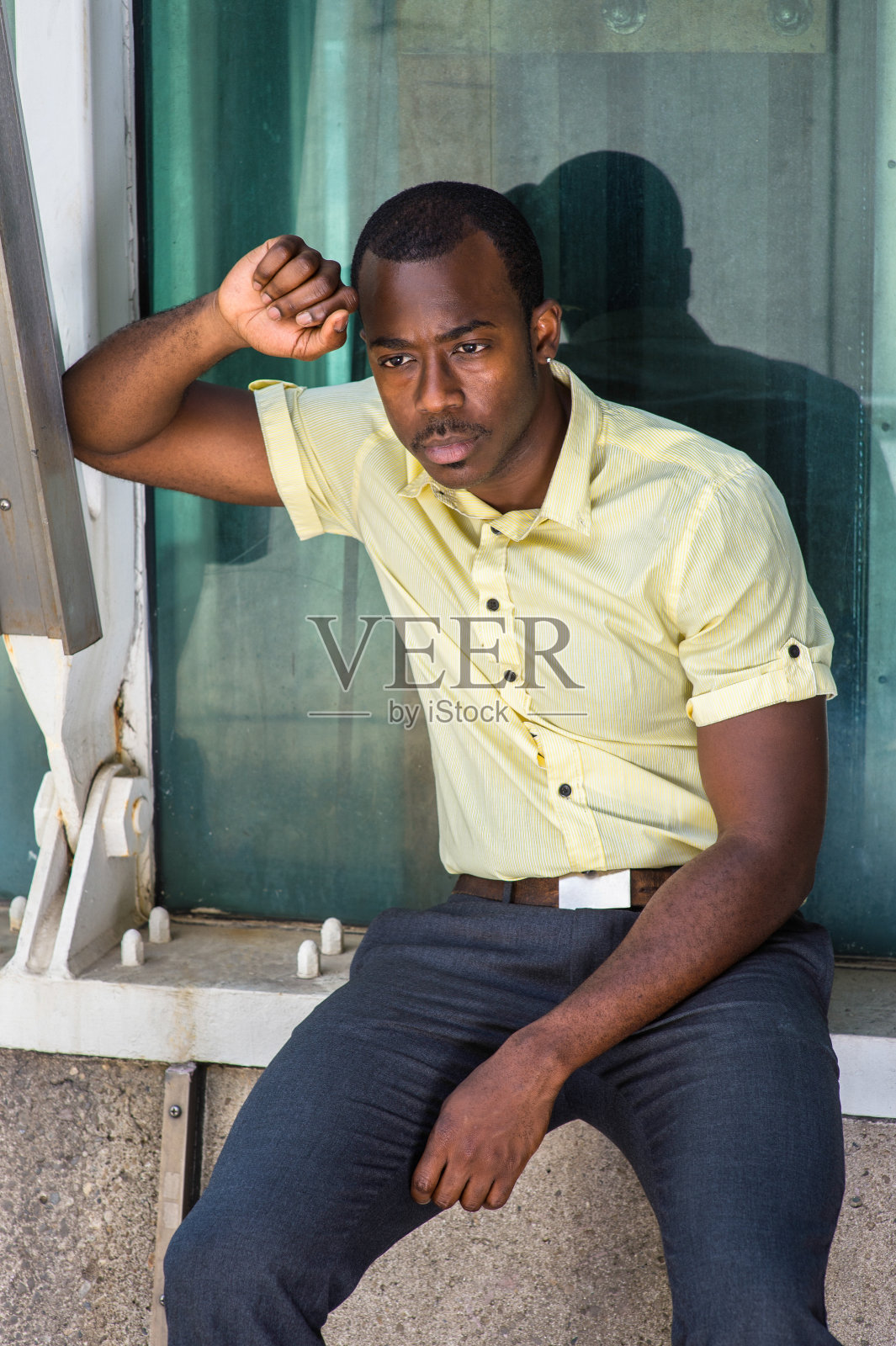 一个年轻人坐在纽约市的户外，思考着照片摄影图片