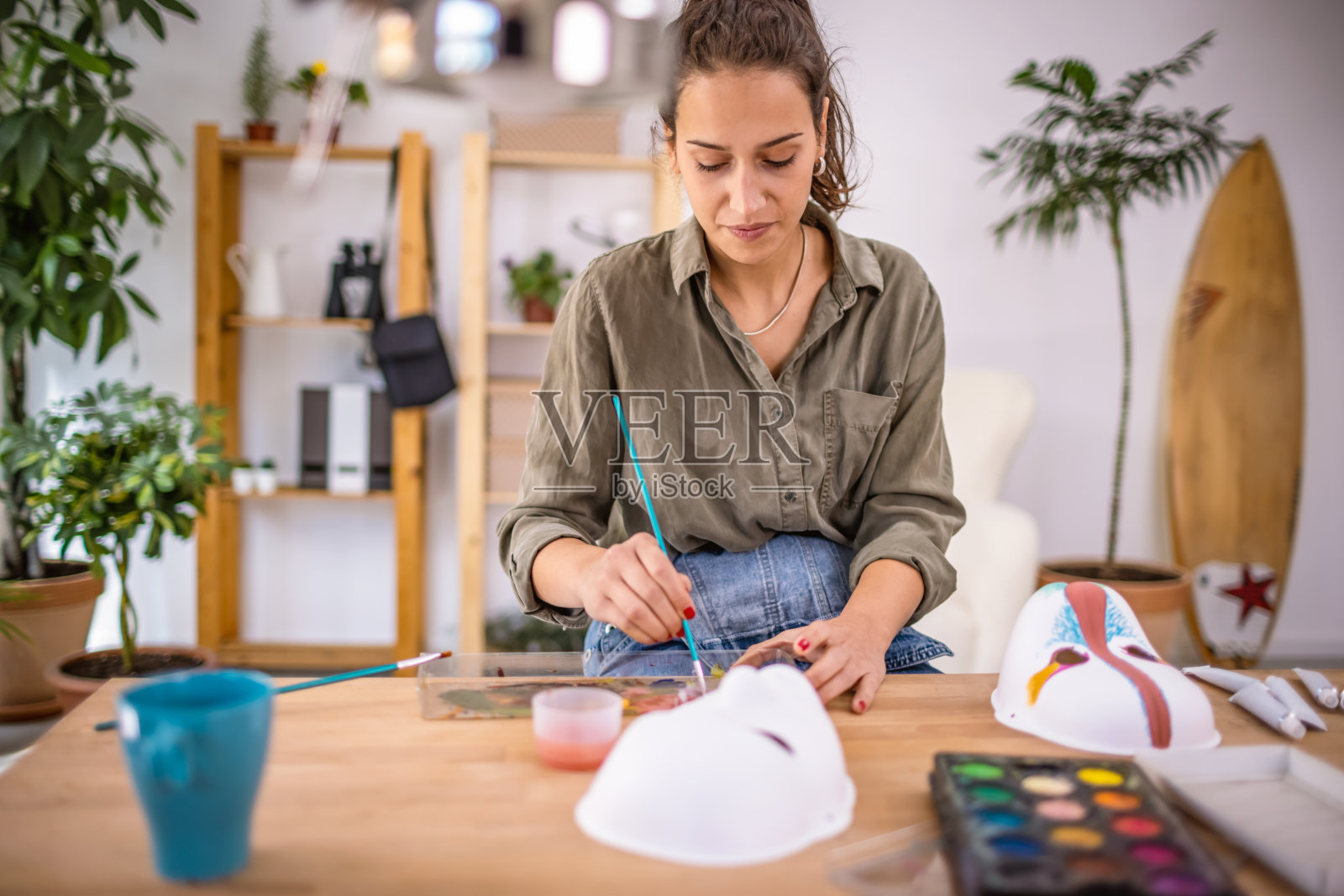 年轻的女艺术家在她的工作室公寓画面具照片摄影图片