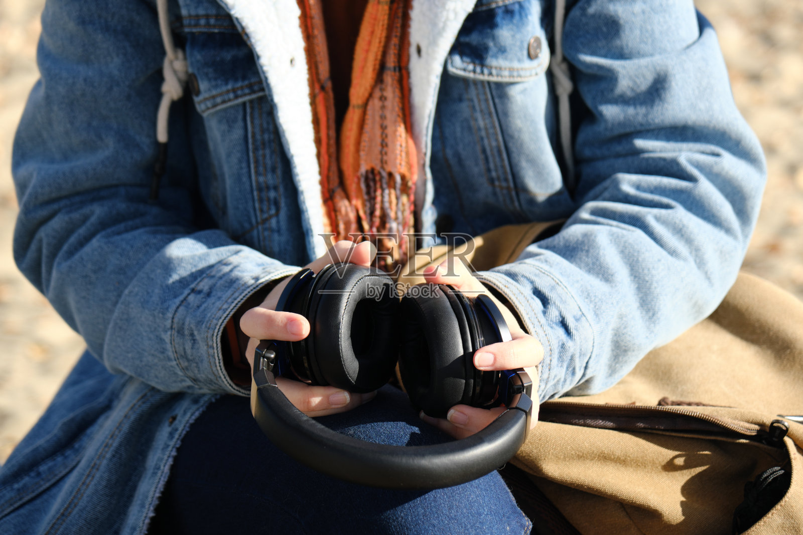 一个女人的手在阳光明媚的秋天自然公园听音乐照片摄影图片