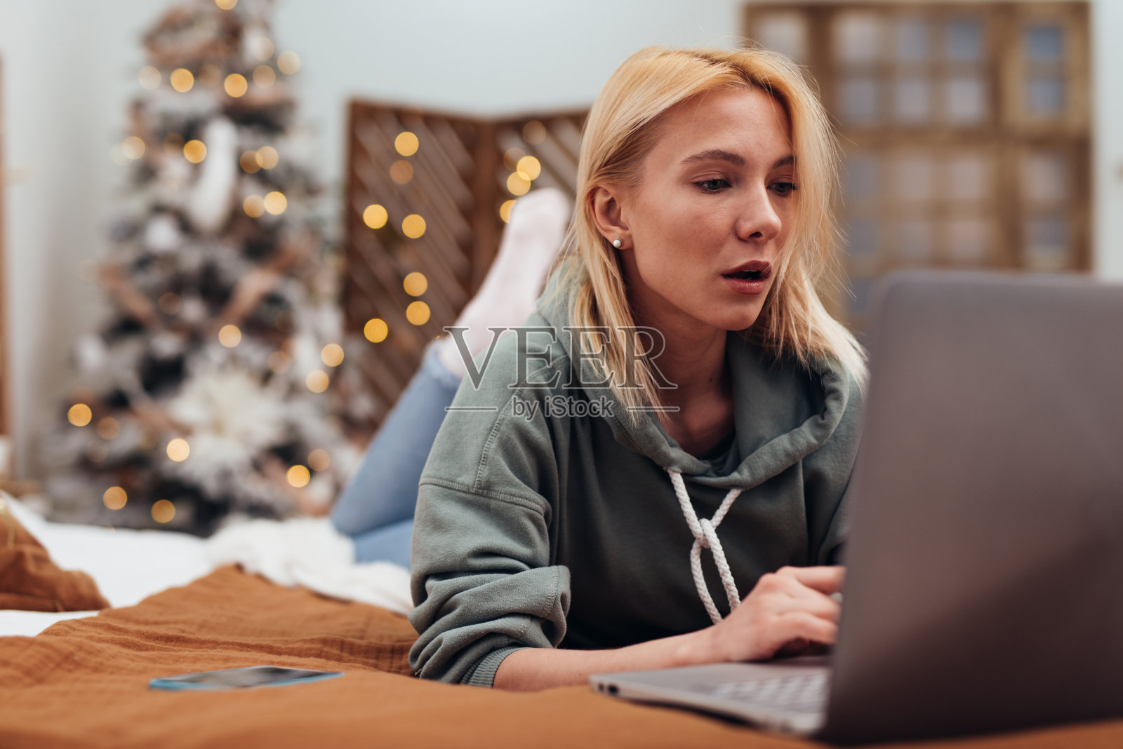 女人在沙发上放松，把笔记本电脑放在家里。照片摄影图片