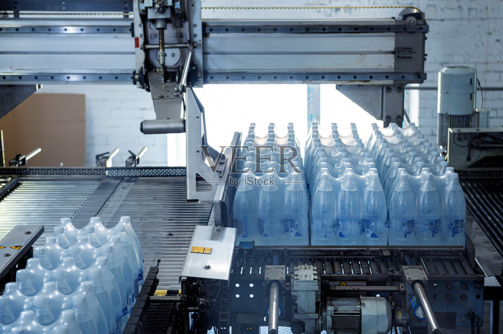 饮料厂包装线用现代化捆扎运输设备。照片摄影图片