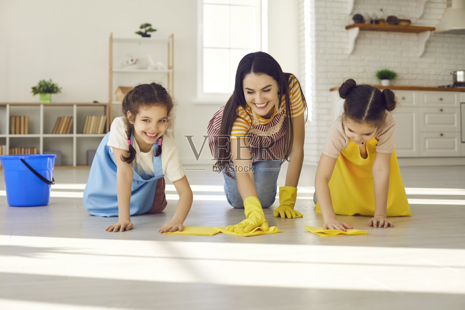 一位快乐的年轻母亲和她可爱的小女儿在一起擦地板照片摄影图片