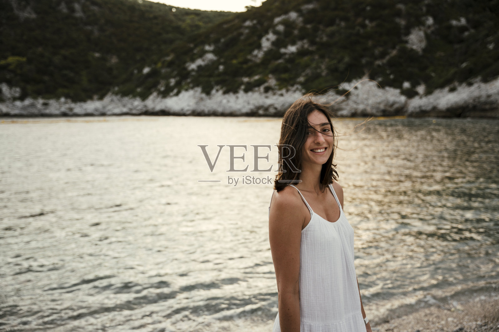 美丽的白人女性走在海边微笑享受蜜月照片摄影图片