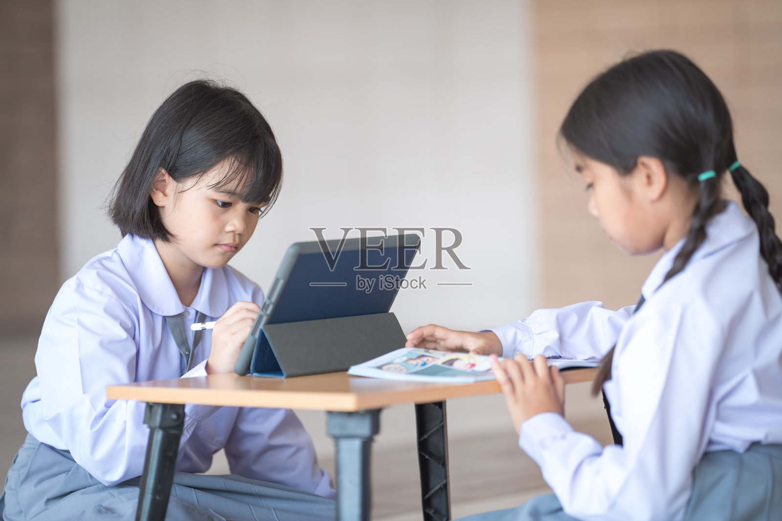 在新冠肺炎疫情封锁后，亚洲儿童和学生朋友们回到学校，一起使用电子平板电脑学习，在笔记本上写字。回到学校概念库存照片照片摄影图片