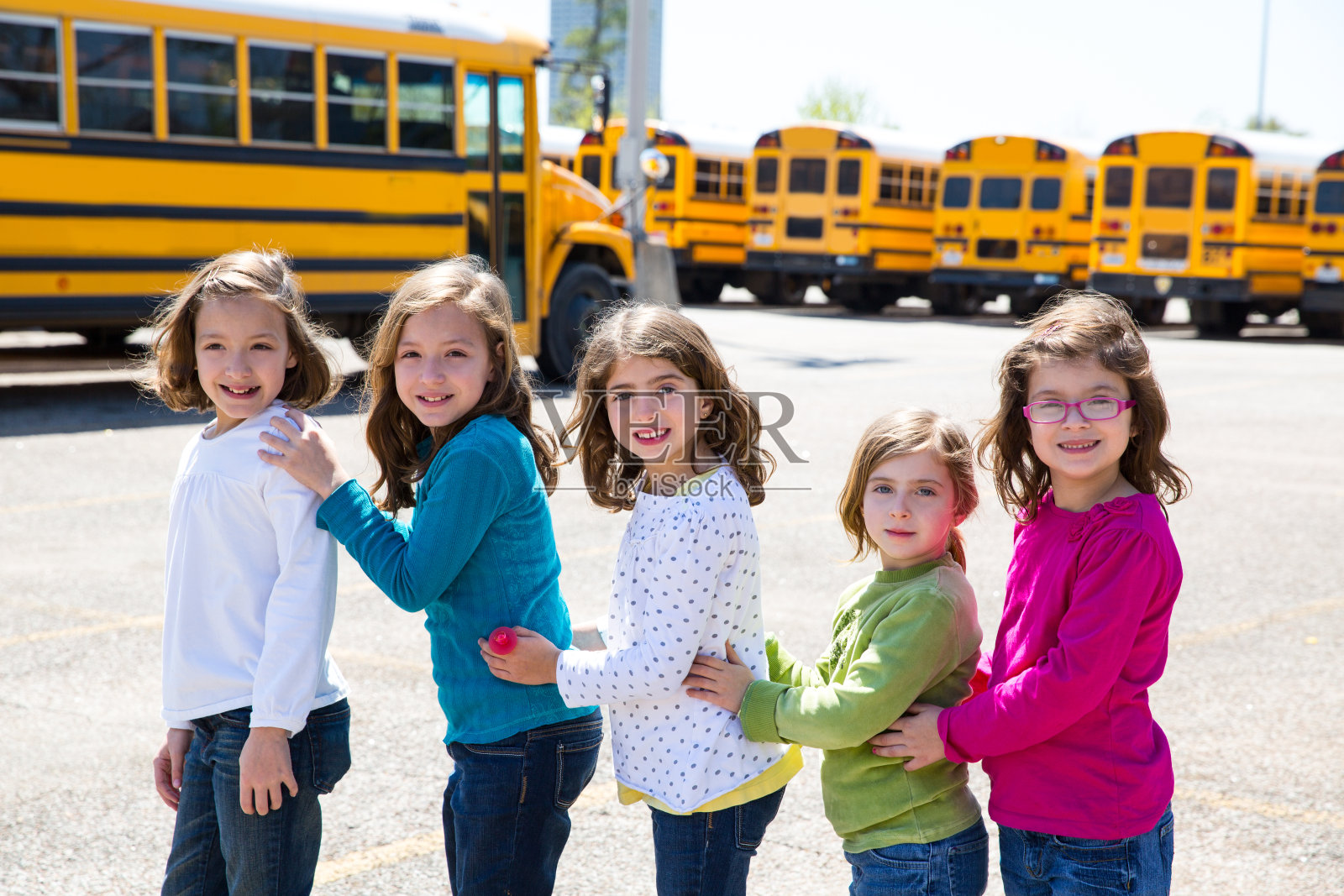 女生们排成一排从校车上走下来照片摄影图片