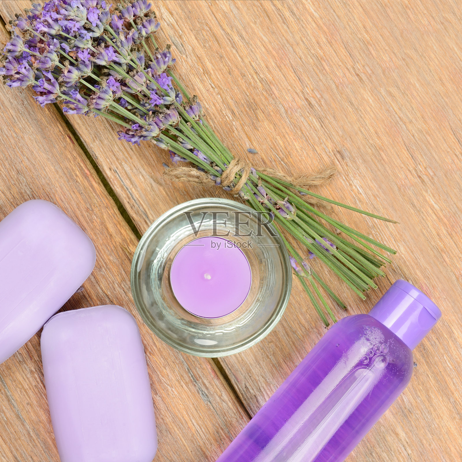 木制背景上摆放着薰衣草花、肥皂、香薰蜡烛和洗发水。美容和水疗产品。照片摄影图片