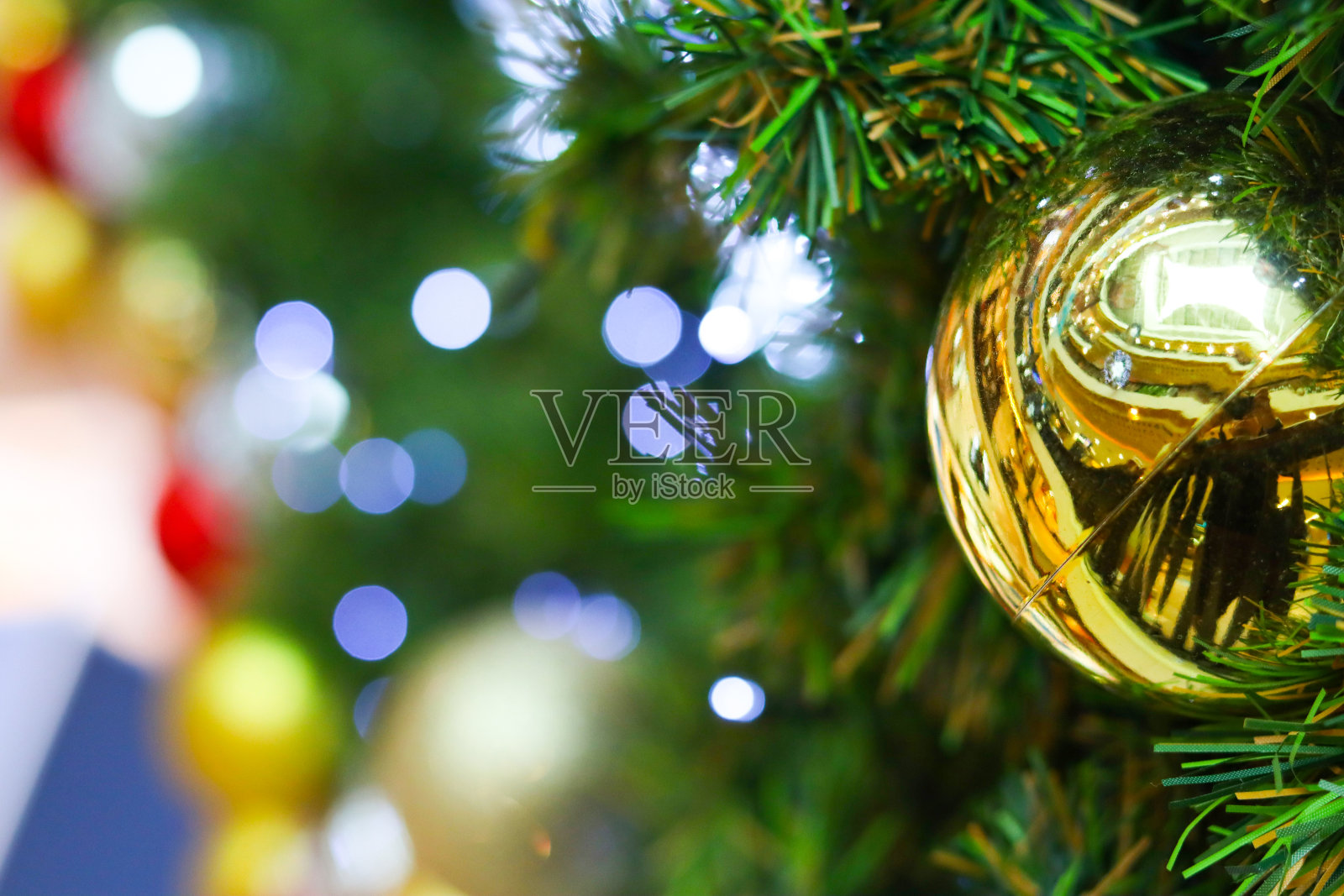 用电灯和彩球装饰的圣诞树。照片摄影图片