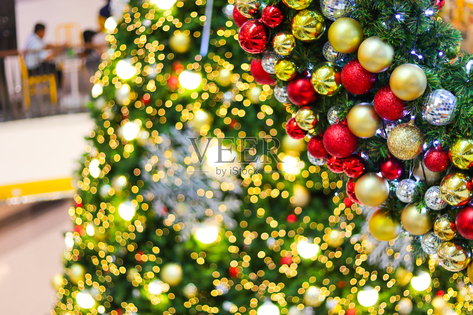 用电灯和彩球装饰的圣诞树。照片摄影图片