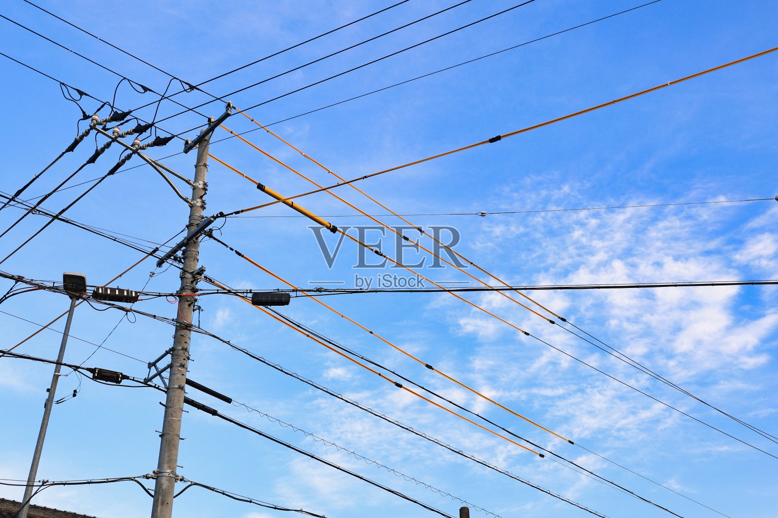 穿过电线杆的电线:晴朗的秋日天空，薄云密布照片摄影图片