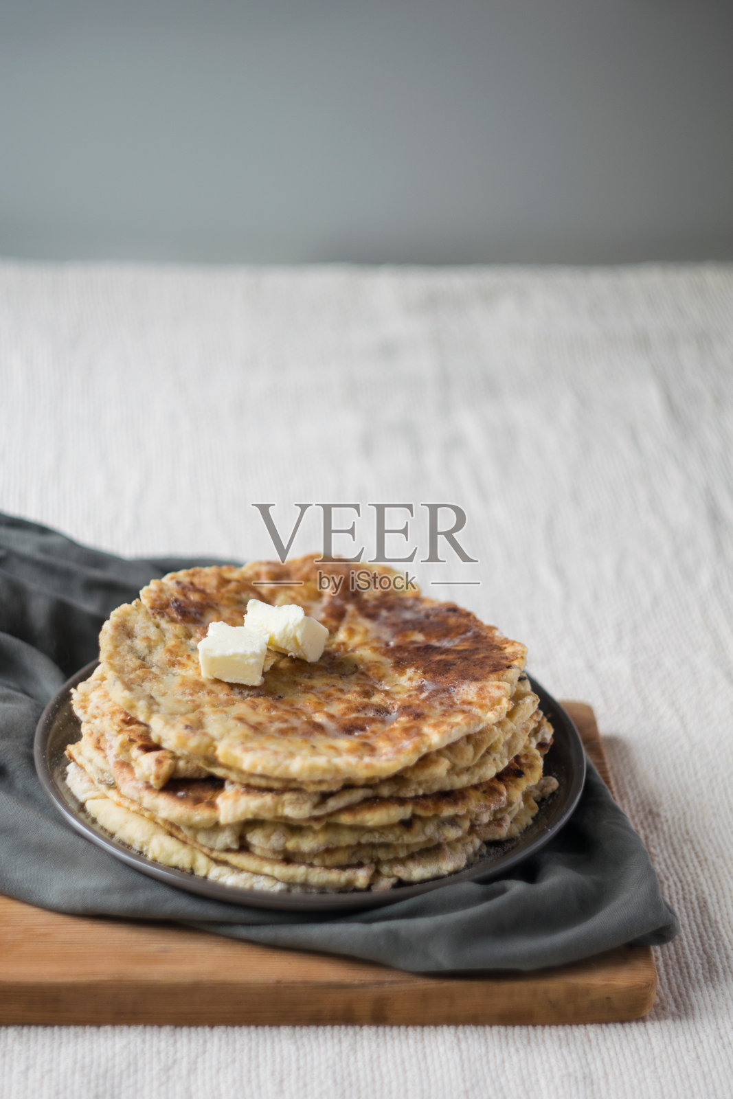 一堆自制的全麦面饼放在亚麻布桌布上，选择性的照片摄影图片