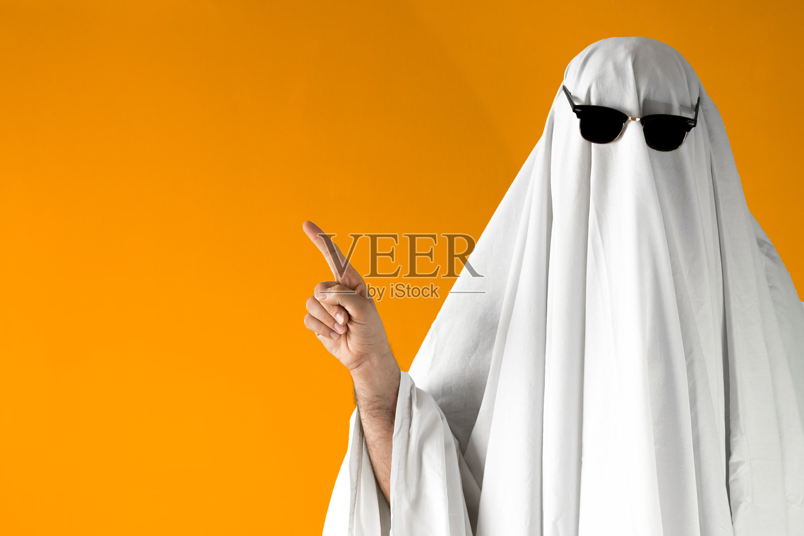 一个戴着墨镜的万圣节鬼魂指着远处照片摄影图片