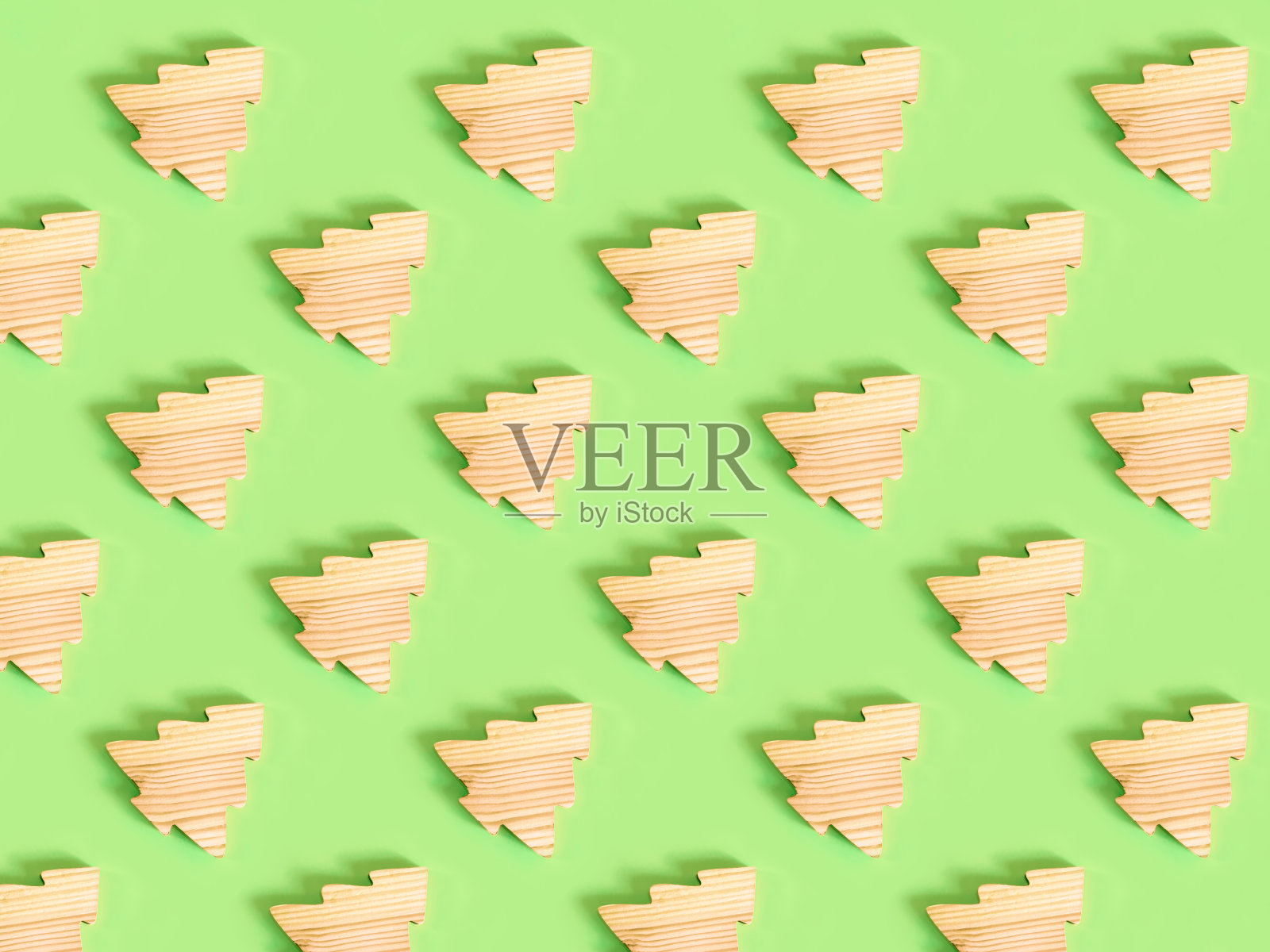 美丽的图案手工制作的木质冷杉树在绿色的背景上。照片摄影图片