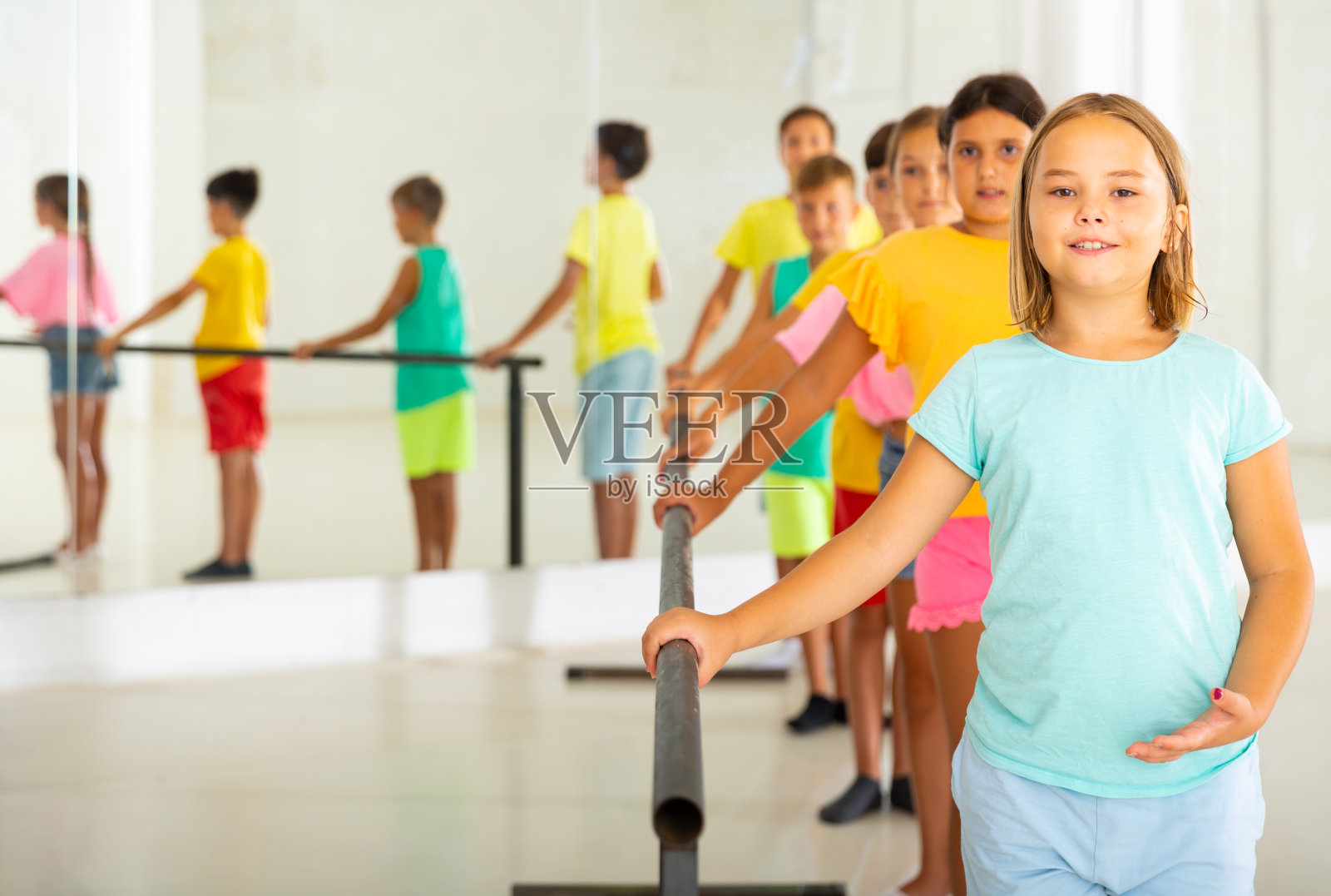 十几岁的小女孩上课时在芭蕾舞杆附近工作照片摄影图片