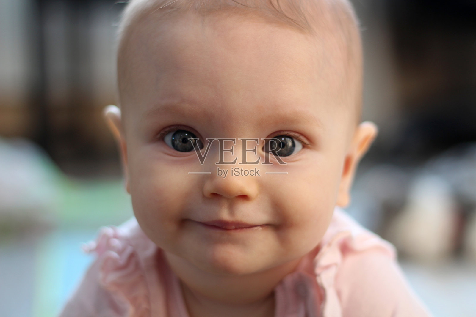 8个月大的微笑女孩的肖像。温馨可爱的室内照片。太阳能照明。肖像在前面。照片摄影图片