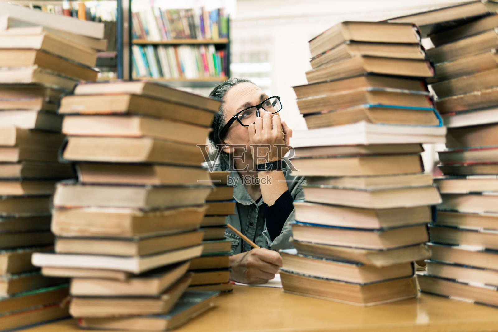 一个女人在图书馆的书架前。教育的概念照片摄影图片