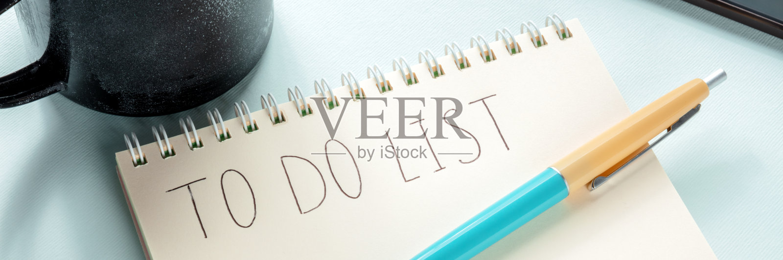 做列表全景图。一个纸笔记本，一个咖啡杯和一支蓝笔照片摄影图片