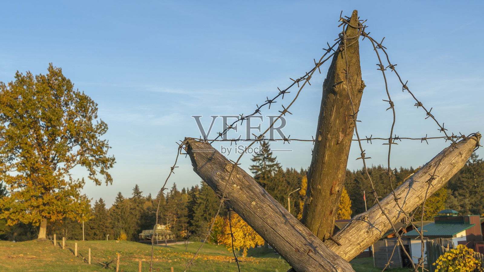 二战时期的木制反坦克屏障。反刺猬铁丝网戏剧性的天空背景。照片摄影图片
