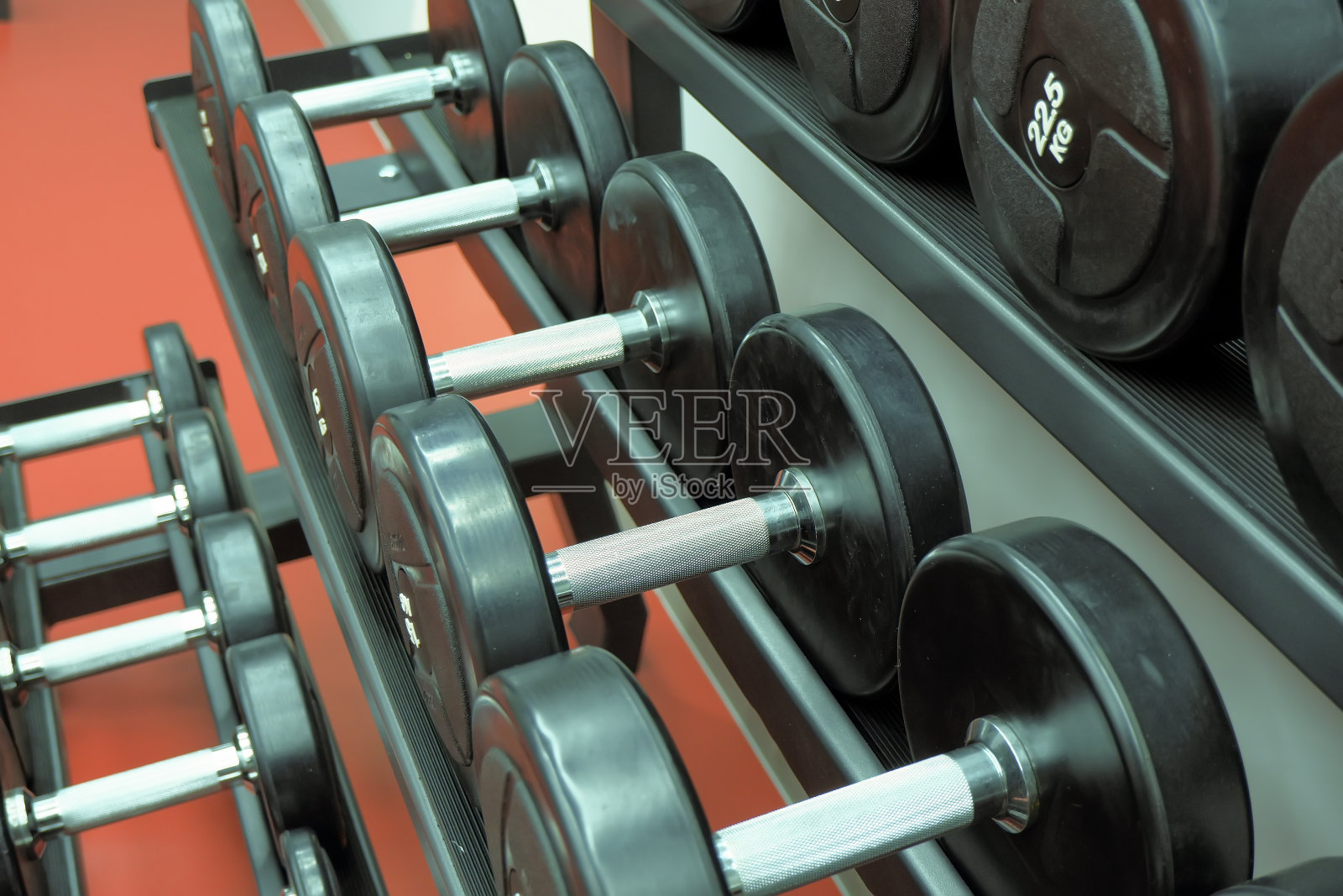 健身课用的哑铃整齐地放在一个架子上。健身、体育运动、力量练习照片摄影图片