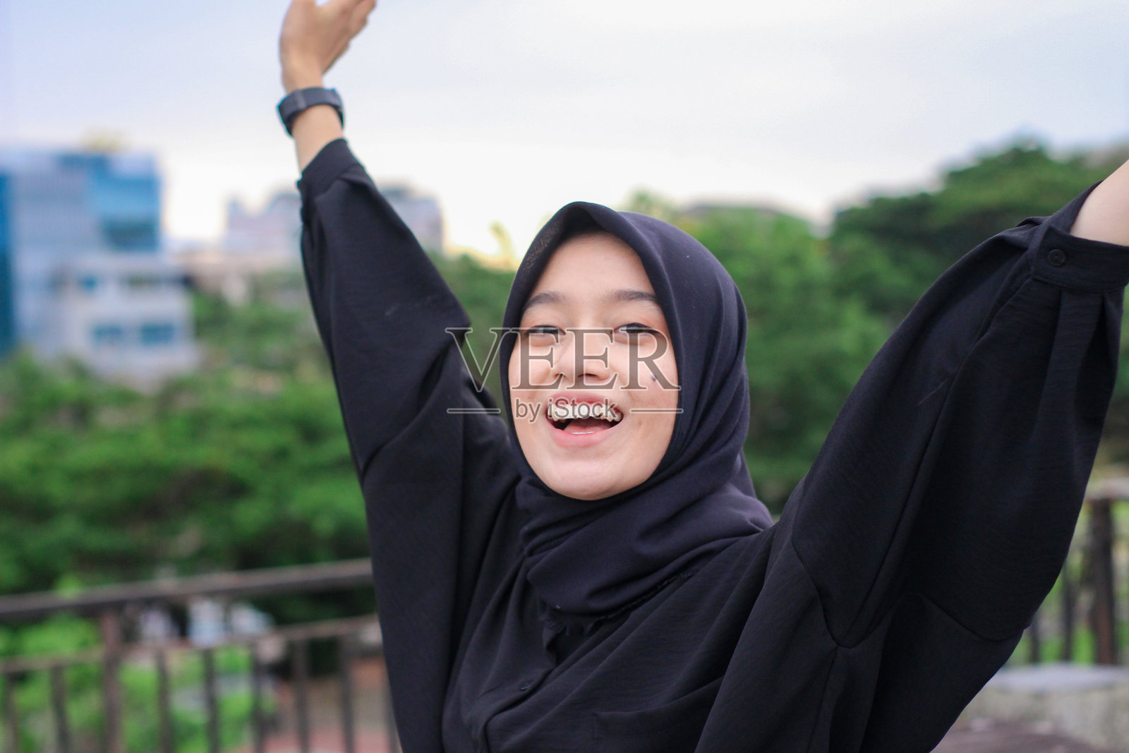 年轻的亚洲妇女戴着头巾在城市公园里享受照片摄影图片