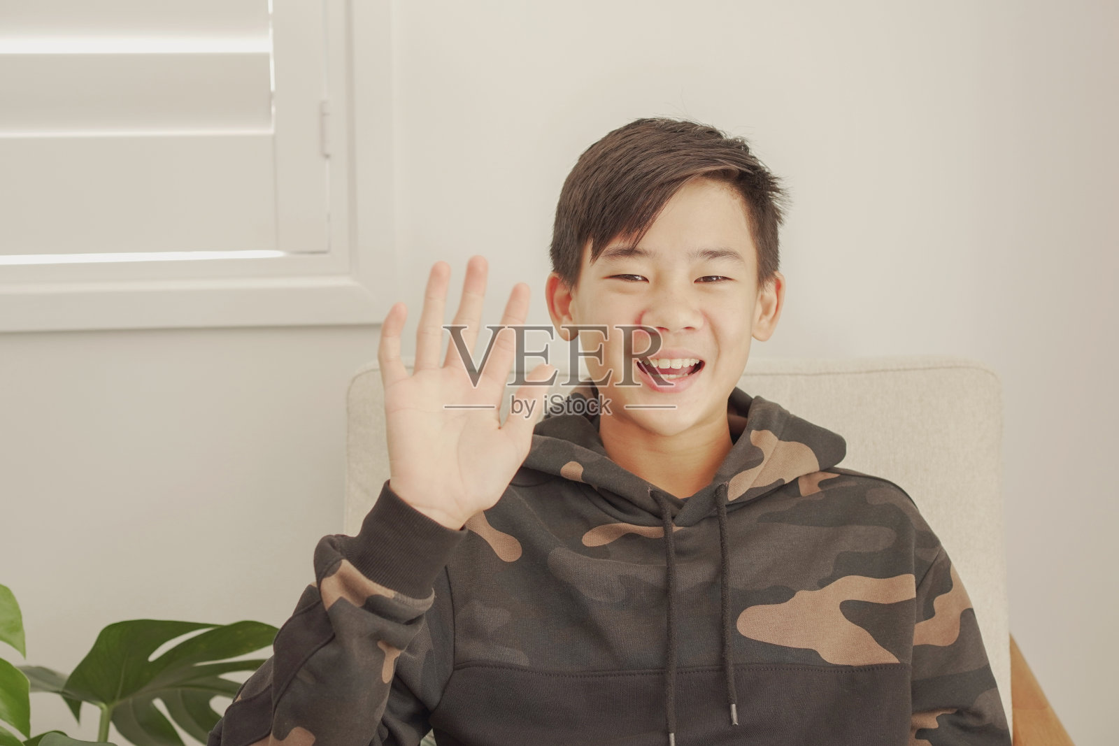 亚洲十多岁男孩在家里视频通话，使用摄像头放大在线虚拟课堂，社交距离，在家上学，新冠疫情期间远程学习，新常态概念照片摄影图片