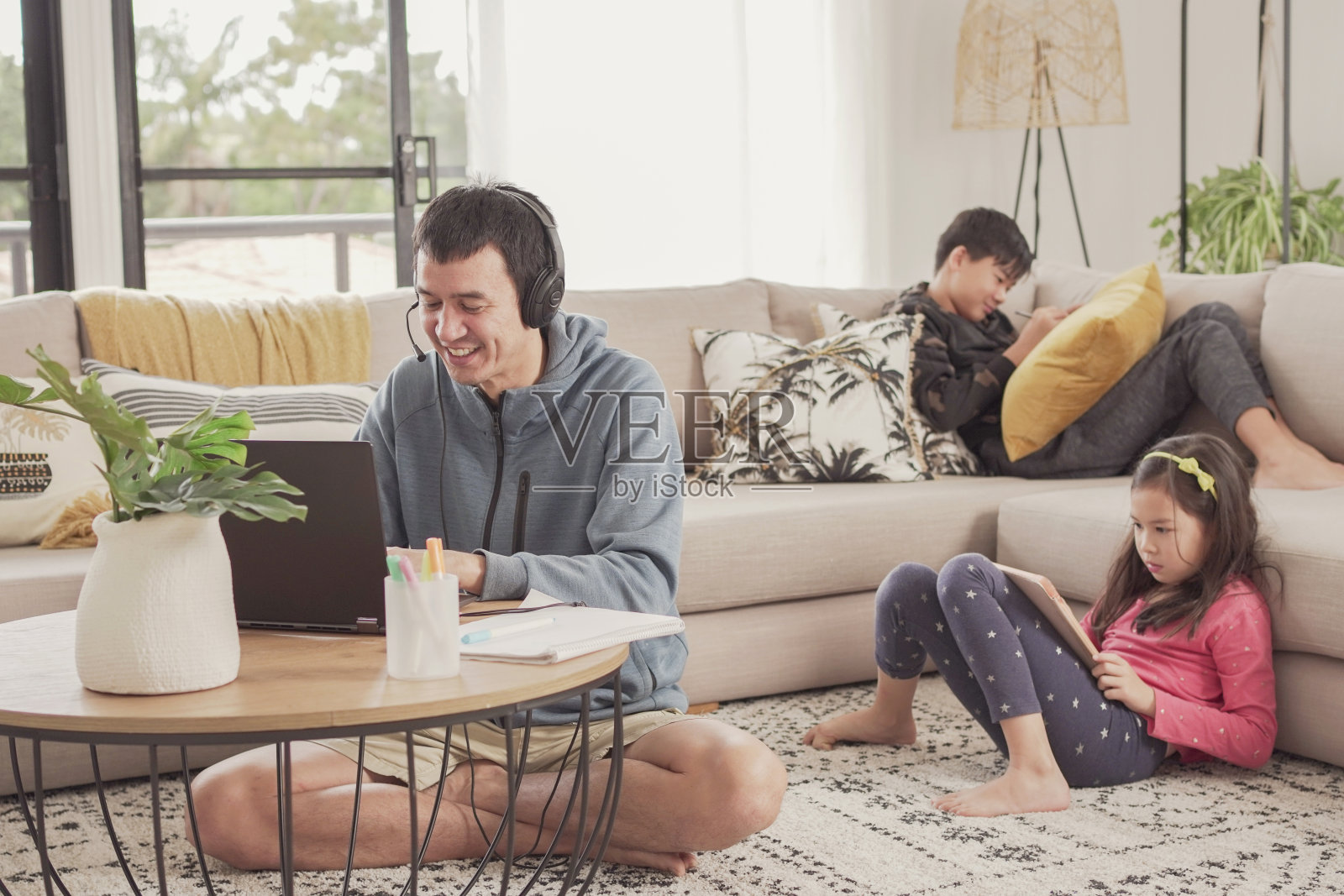 父亲在家带着孩子工作。在家上学、呆在家里、covid - 19大流行期间保持社交距离、自由职业、新常态概念照片摄影图片