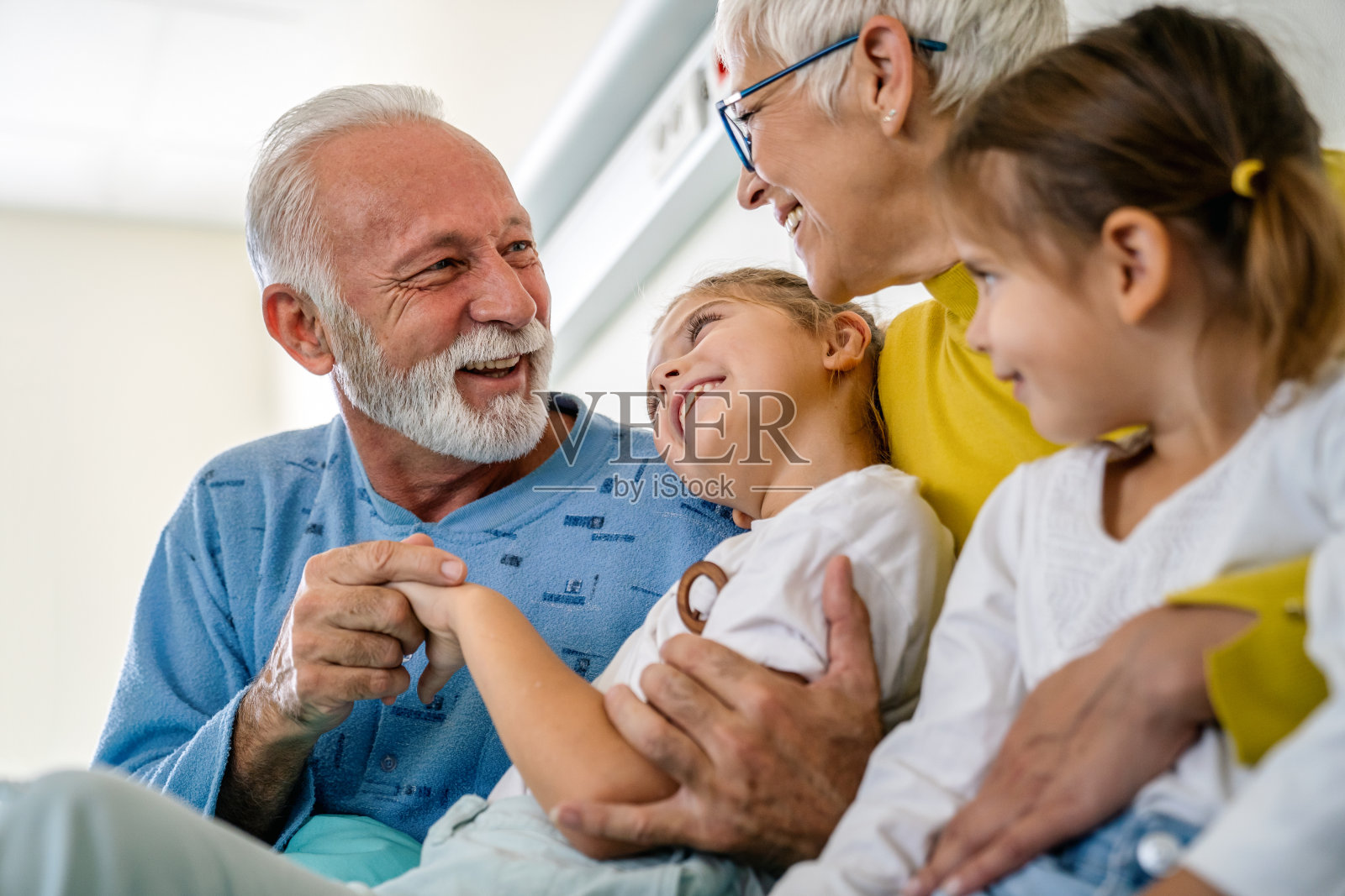 快乐的孩子们和他们的祖父母一起玩耍和爱。家庭让人快乐的概念照片摄影图片