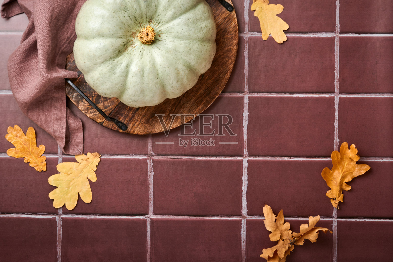 南瓜。秋天的食物背景与肉桂，坚果和季节香料在旧瓷砖的背景。为感恩节和秋季假期做南瓜或苹果派和饼干。前视图。照片摄影图片