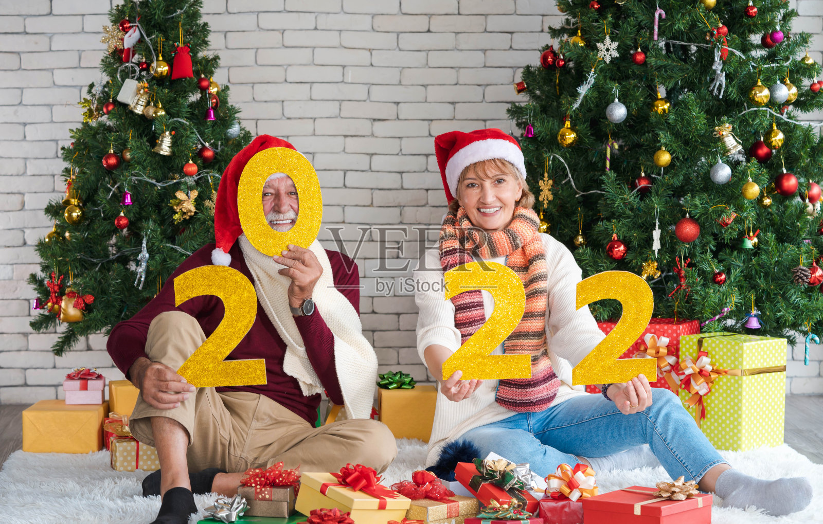 幸福快乐的白种人夫妇手持黄色的闪光数字的新年2022庆祝新年，新生活和圣诞节在家里一起。照片摄影图片