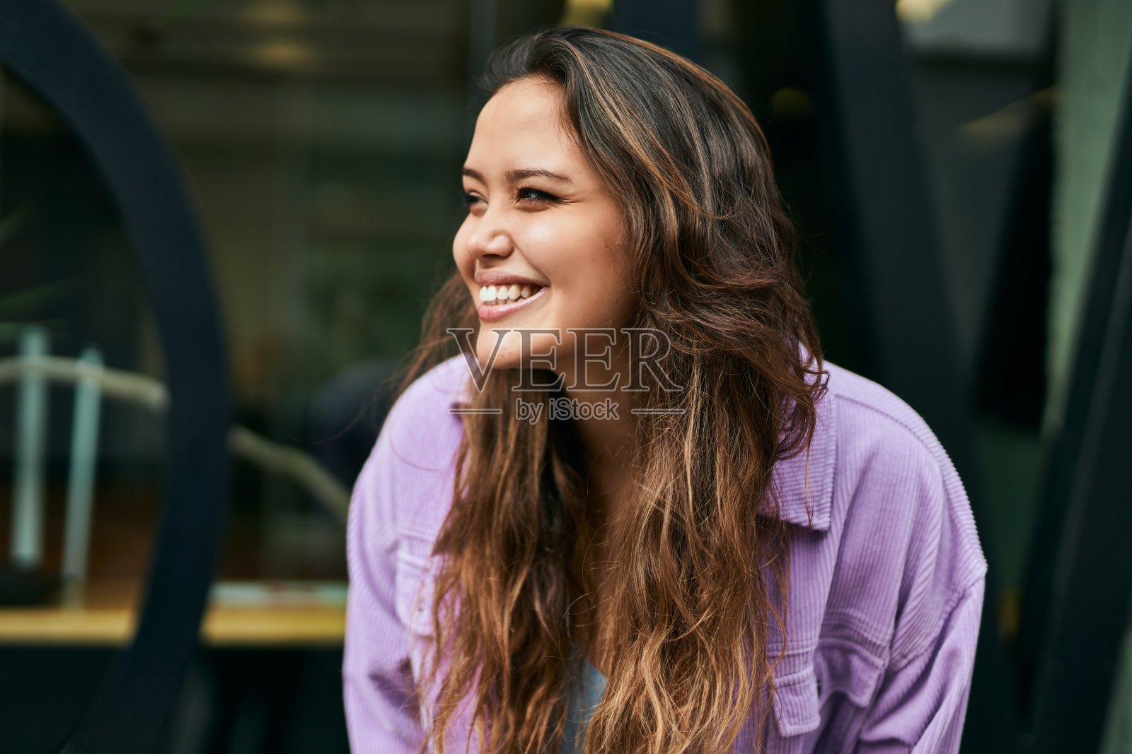 年轻的西班牙妇女微笑着幸福地站在城市。照片摄影图片