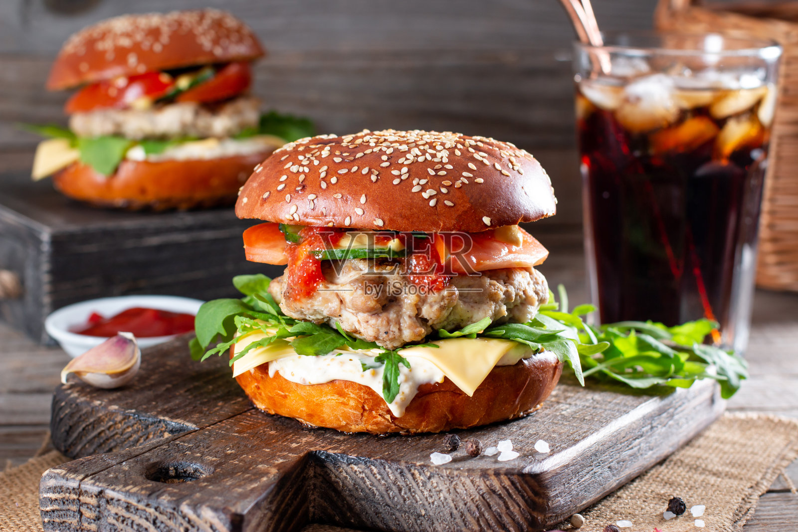 汉堡里有肉排，番茄，芝麻菜，黄瓜，洋葱和奶酪。美国菜。快餐。照片摄影图片