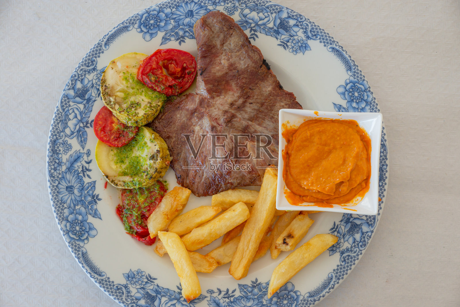 一盘伊比利亚猪肉与天然番茄片的细节照片摄影图片