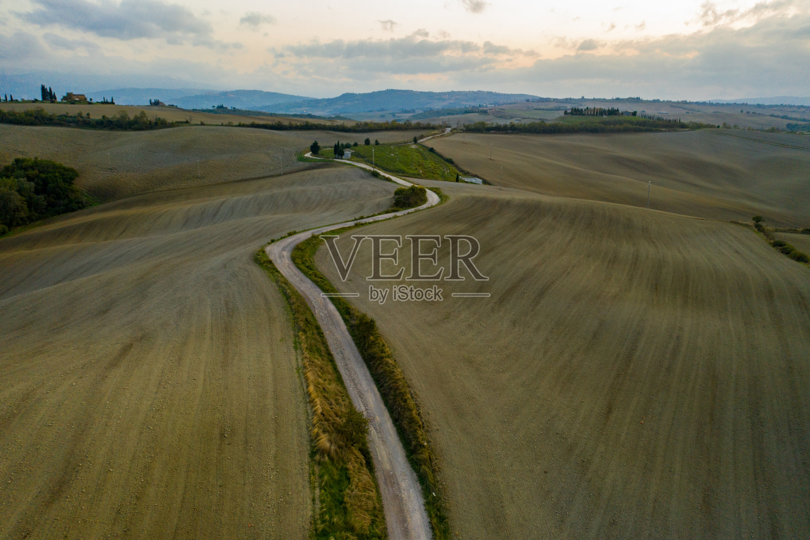 托斯卡纳日落时的乡村景观鸟瞰图。乡村农场，柏树，绿色的田野，阳光和云彩。意大利,欧洲照片摄影图片