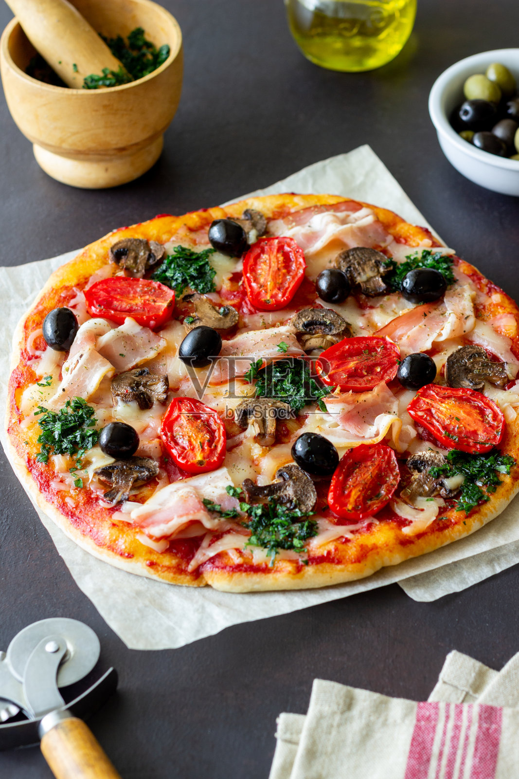 有培根、蘑菇、西红柿、奶酪和橄榄的披萨。意大利菜。照片摄影图片