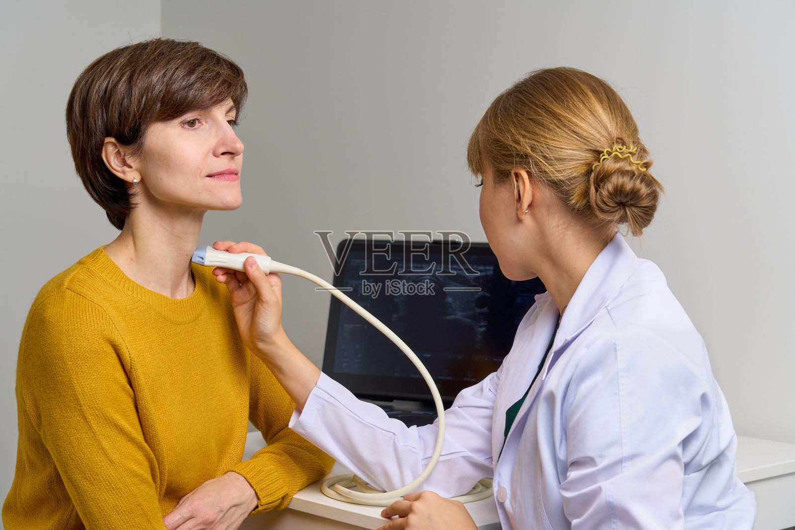 医生正在做喉咙和颈动脉血管的超声波检查。USG扫描仪照片摄影图片