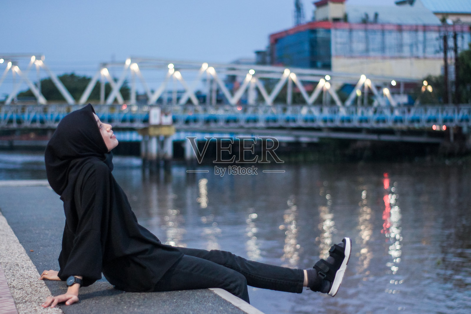 亚洲妇女在城市公园里坐着享受照片摄影图片