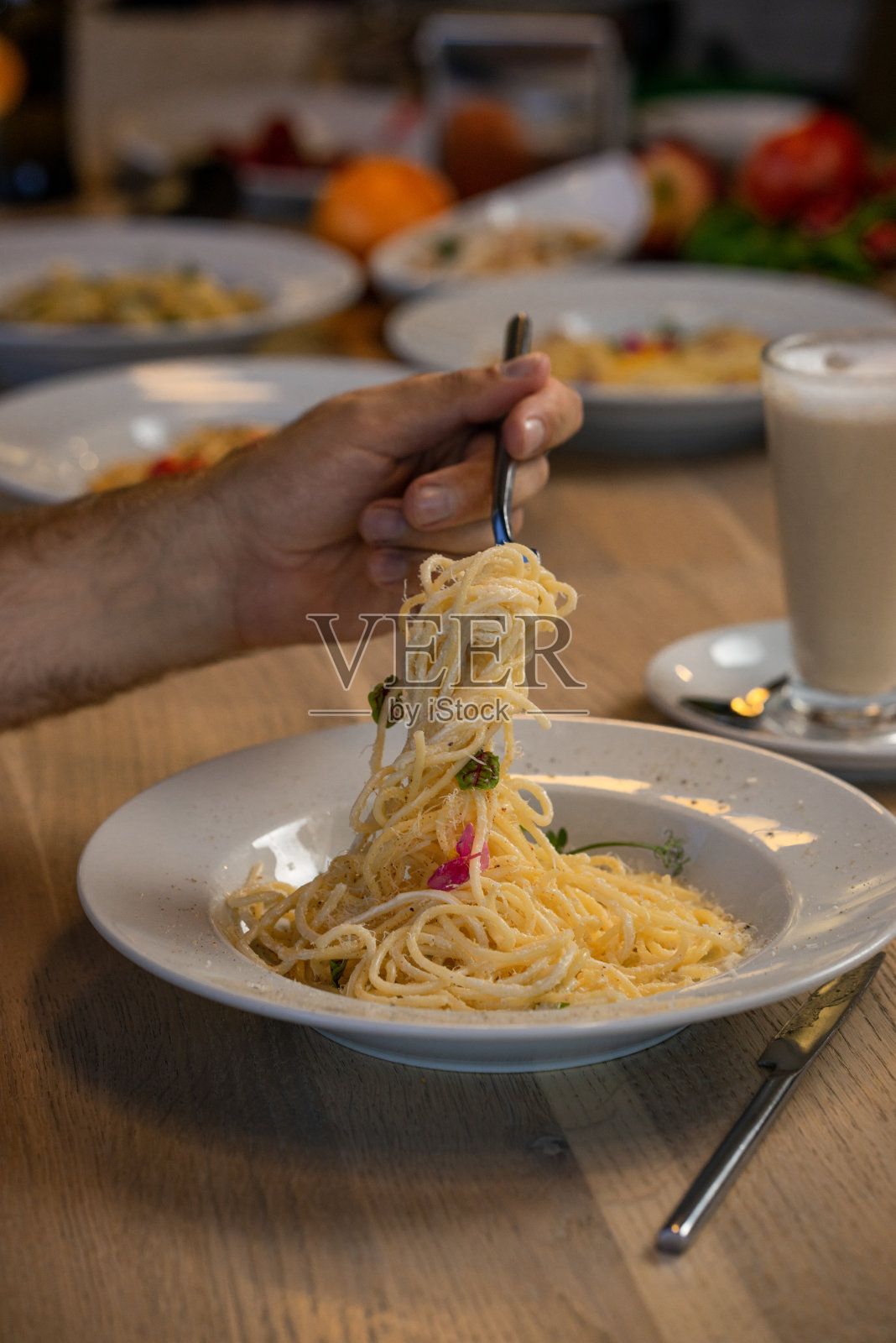 传统的意大利通心粉和蔬菜，放在白色盘子里，用叉子叉着照片摄影图片