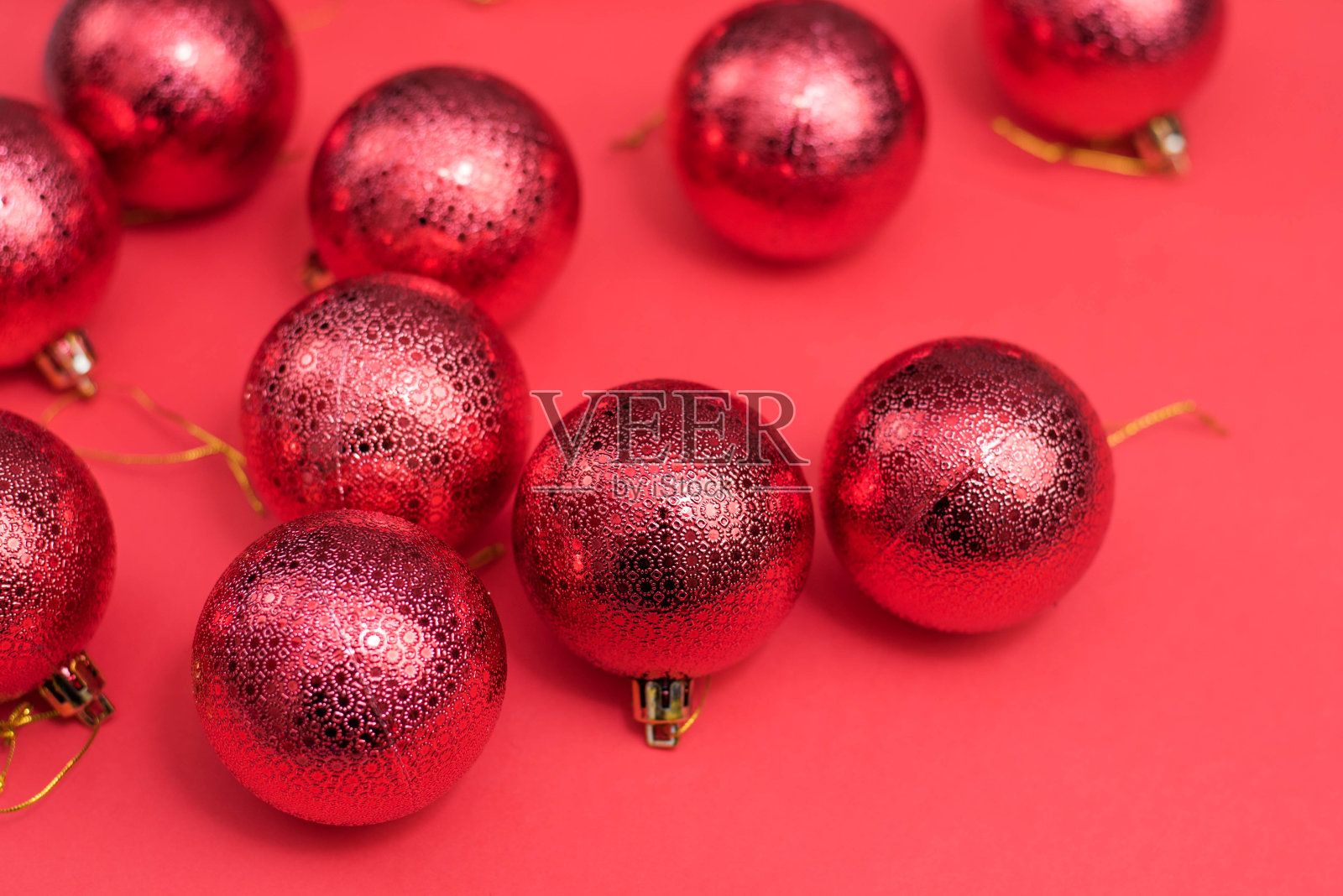 红色圣诞小玩意装饰在红色背景上。新年贺卡。最小的风格。平的。照片摄影图片