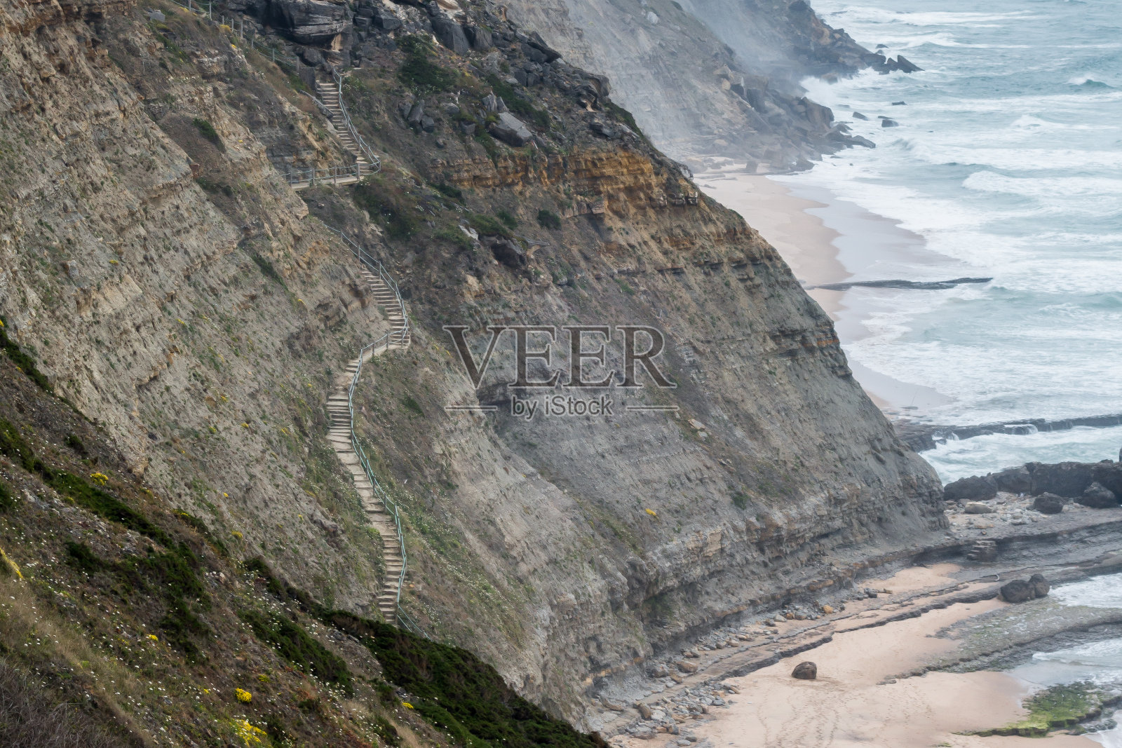 宏伟的楼梯嵌入陡峭的海岸悬崖通往海滩照片摄影图片